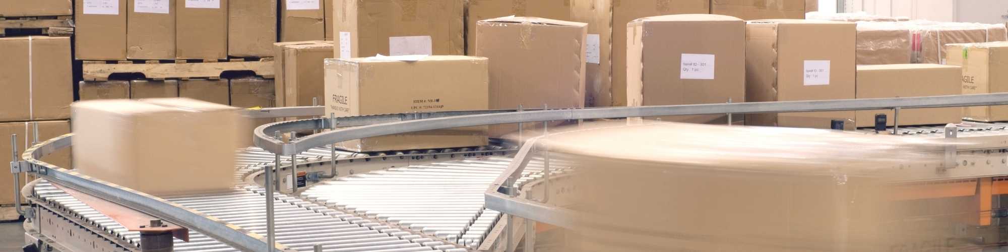 Warehouse automation showing parcels on a conveyor surrounded by pallets of boxes