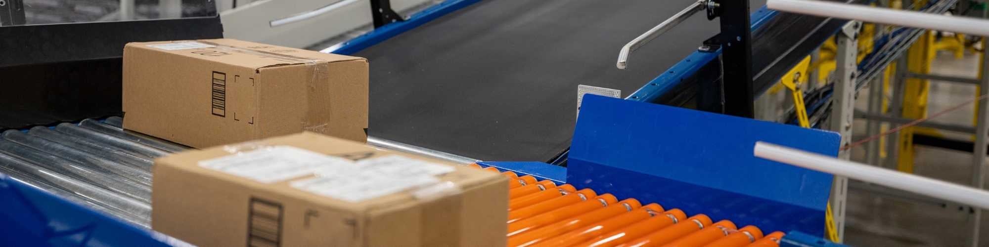 packages enter conveyor belt for eCommerce fulfillment automation